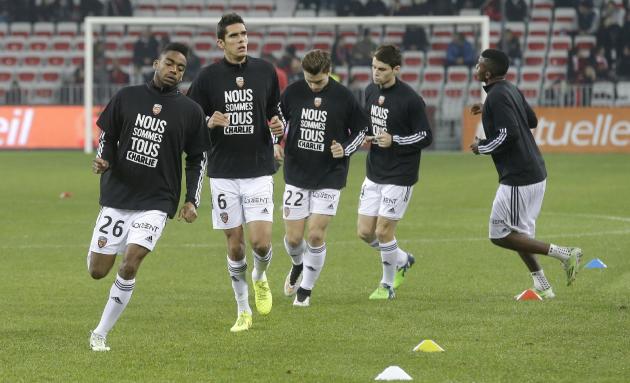 Lorient's Yoann Watcher, foreground and teammates wear T-shirts reading "We are all Charlie" for victims of the shooting at the satirical newspaper Charlie Hebdo, Saturday, Jan. 10, 2015, in Nice stad
