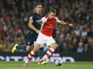 Arsenal's Lukas Podolski, right, controls the ball ahead of Southampton's Dusan Tadic during the English League Cup soccer match between Arsenal and Southampton at Emirates Stadium in London, Tuesday, Sept. 23, 2014. (AP Photo/Kirsty Wigglesworth)