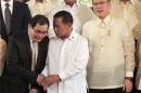 MILF chief negotiator Iqbal listens to Philippine   Vice President Binay as they stand near Philippine President Aquino after the   turnover ceremony of the draft Bangsamoro Basic Law in Manila