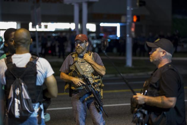 Members of the Oath Keepers walk with their personal weapons on the street during protests in Ferguson, Missouri August 11, 2015. Police in riot gear clashed with protesters who had gathered in the streets of Ferguson early on Tuesday to mark the anniversary of the police shooting of an unarmed black teen whose death sparked a national outcry over race relations. REUTERS/Lucas Jackson