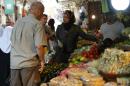 La profesora de cocina palestina Fatima Kadumy (centro) compra productos con dos turistas extranjeros en un mercado de Nablús, el 19 de septiembre de 2015