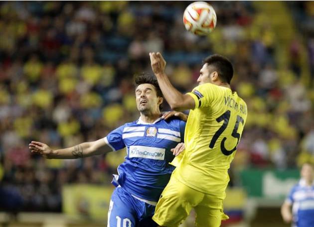GRA440. VILLARREAL (CASTELLÓN), 02/10/2014.- El defensa del Villarreal Víctor Ruiz (d) lucha un balón con el delantero del Apollon Limassol Gaston Sangoy (i), durante el partido de la segunda jornada 