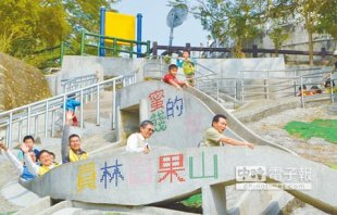 員林市長張錦昆（前排右）以「我的少男時代」裝扮，開心玩百果山兒童樂園幸福溜滑梯，重溫兒時樂趣。（鐘武達攝）
