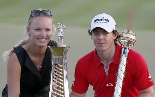 McIlroy posa junto a su novia, Caroline Wozniacki, y los trofeos de vencedor del torneo de Dubái el 25 de noviembre