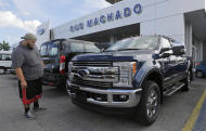 In this Tuesday, Jan. 17, 2017, photo, a potential customer looks at a 2017 Ford F-250 Lariat FX4 at a Ford dealership, in Hialeah, Fla. Ford Motor Company reports financial results Thursday, Jan. 26, 2017. (AP Photo/Alan Diaz)