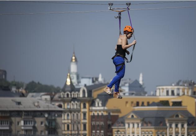 Mariya Gafitsa, 23, rides a Tyrolean traverse over the Dnipro River, suspended by a cable wire with metal clamps pierced directly into the skin of her back during the attempt to set a national record 