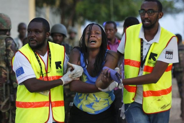 Dos sanitarios ayudan a una mujer que ha escapado de la Universidad de Garissa, en el este de Kenia, donde al menos 15 personas han muerto y otras 65 han resultado heridas en un ataque con rehenes reivindicado por el grupo islamista Al Shabab, hoy, jueves 2 de abril de 2015. En estos momentos, se está llevando a cabo una acción conjunta de las Fuerzas de Defensa y la Policía que ya ha conseguido evacuar tres de las cuatro residencias universitarias, mientras que los atacantes siguen atrincherados en una de ellas con un número desconocido de rehenes. EFE/Dai Kurokawa