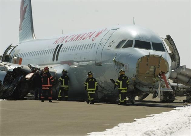 RETRANSMISSION TO INCLUDE POOL PHOTO DESIGNATION Transportation Safety Board invesigators and airport firefighters work at the crash site of Air Canada AC624 that crashed early Sunday morning during a snowstorm, at Stanfield International Airport in Halifax on Monday, March 30, 2015. The flight had 133 passengers and five crew members. THE CANADIAN PRESS/Andrew Vaughan-Pool
