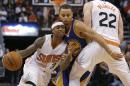 El jugador de los Suns de Phoenix Isaiah Thomas (con el 3) pasa junto al jugador de los Warriors de Golden State Stephen Curry (con el 30) en una jugada con Miles Plumlee (22) en la segunda mitad de su partido de NBA, el 9 de noviembre de 2014 en Phoenix, EEUU. (AP Foto/Rick Scuteri)