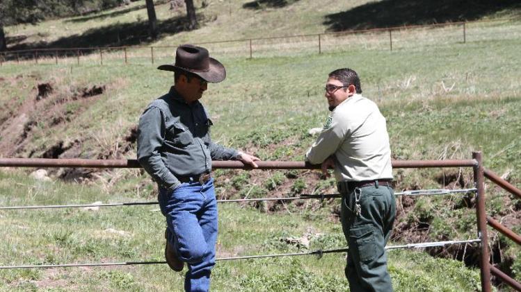 Otero cattle rancher association president Gary Stone talks to Lincoln National Forest District Ranger James Duran in Weed, New Mexico, Thursday, May 15, 2014. The Otero County Cattleman's Association is pitted against the National Forest Service over a fence intended to protect wildlife that the agency installed around a small creek where the ranchers' cattle drink water. (AP Photo/Juan Carlos Llorca)