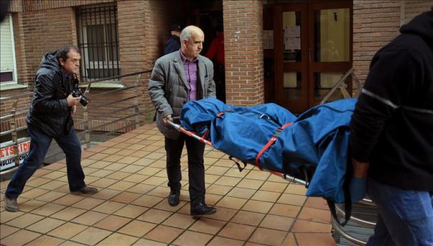 Trabajadores de servicios funerarios trasladan el cuerpo de una de las dos mujeres, madre e hija, halladas muertas y ensangrentadas en su vivienda de la localidad vizcaína de Abadiño. EFE