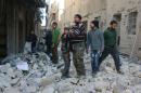 Des Syriens dans les décombres de bâtiments détruits par des frappes aériennes, le 4 février 2016 à Alep