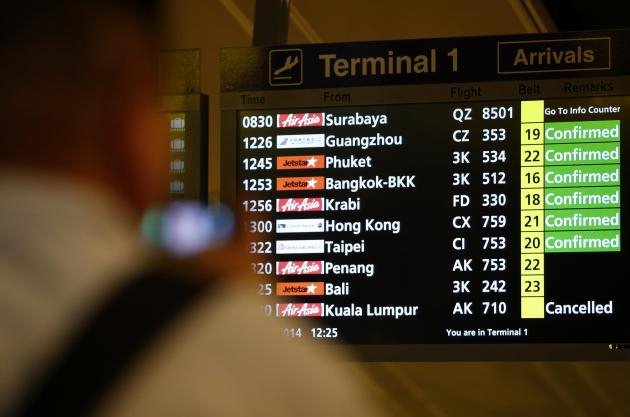 A flight information signboard shows the status of AirAsia flight.