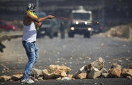 A Palestinian demonstrator readies to hurl a stone during clashes with Israeli troops near Ramallah, West Bank, Tuesday, Sept. 29, 2015. Palestinian demonstrators clashed with Israeli troops across the West Bank on Tuesday as tensions remained high following days of violence at Jerusalem’s most sensitive holy site, revered by Jews as the Temple Mount and by Muslims as the Noble Sanctuary. (AP Photo/Majdi Mohammed)