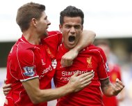 Liverpool's Philippe Coutinho (R) celebrates with Steven Gerrard after scoring during their English Premier League soccer match against Queens Park Rangers at Loftus Road in London October 19, 2014. REUTERS/Eddie Keogh (BRITAIN - Tags: SOCCER SPORT) FOR EDITORIAL USE ONLY. NOT FOR SALE FOR MARKETING OR ADVERTISING CAMPAIGNS. EDITORIAL USE ONLY. NO USE WITH UNAUTHORIZED AUDIO, VIDEO, DATA, FIXTURE LISTS, CLUB/LEAGUE LOGOS OR 'LIVE' SERVICES. ONLINE IN-MATCH USE LIMITED TO 45 IMAGES, NO VIDEO EMULATION. NO USE IN BETTING, GAMES OR SINGLE CLUB/LEAGUE/PLAYER PUBLICATIONS.