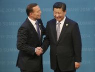 In this Nov. 15, 2014 photo, Australian Prime Minister Tony Abbott, left, welcomes Chinese President Xi Jinping to the G-20 summit in Brisbane, Australia. Abbott, who rose to power in large part by opposing a tax on greenhouse gas emissions, is finding his country isolated like never before on climate change as the U.S., China and other nations signal new momentum for action. (AP Photo/Rob Griffith)