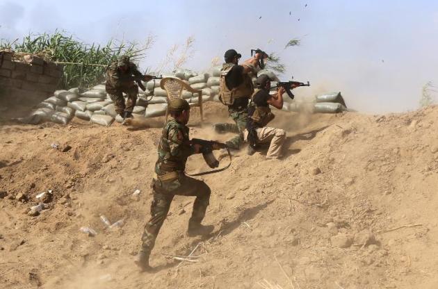 Milicianos suníes iraquíes combaten junto a las fuerzas del Gobierno a los yihadistas del grupo Estado Islámico (EI) situados en las afuerzas de la refinería de Baiji, a unos 200 km al norte de Bagdad, el 25 de mayo de 2015