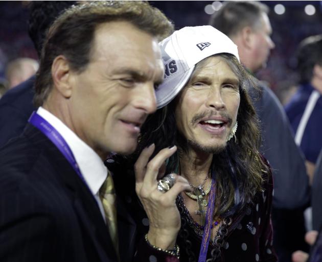 Singer Steven Tyler, right, celebrates on the field with former NFL quarterback Doug Flutie after the NFL Super Bowl XLIX football game between the Seattle Seahawks and the New England Patriots Sunday