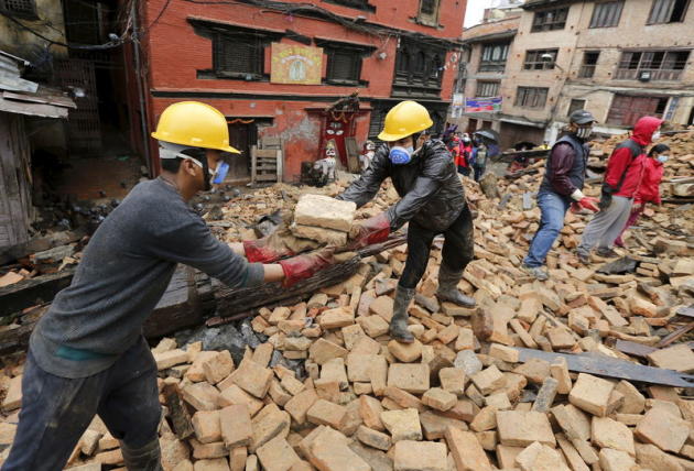 Volontaires déblayant des débris à la recherche de victimes, à Katmandou. Le bilan du séisme de samedi au Népal pourrait s'élever à 10.000 morts, selon le Premier ministre Sushil Koirala. Le dernier bilan du ministère de l'Intérieur fait état de 4.682 personnes tuées par le séisme de magnitude 7,9 qui a frappé la région de Katmandou samedi. /Photo prise le 28 avril 2015/REUTERS/Wolfgang Rattay