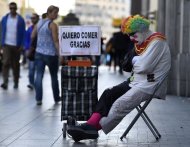 Un hombre disfrazado de payaso, 'Rayito', pide ayuda en la calle para comer, en la Gran Vía madrileña el 28 de octubre de 2014