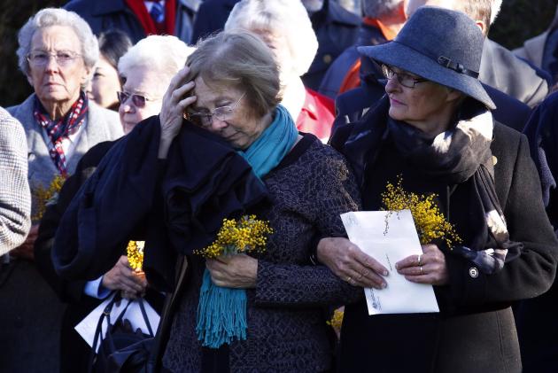 Familiares de australianos que viajaban en el avión de Malaysia Airlines derribado sobre el este de Ucrania asisten a una ceremonia de recuerdo en el exterior del parlamento australiano, en la capital Canberra, el 17 de julio de 2015. (Foto AP/David Gray, Pool)