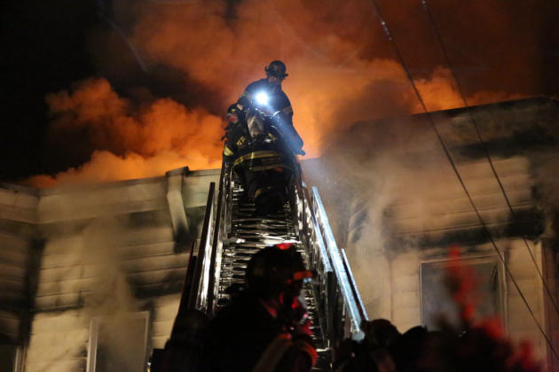 Firefighters battle a fire that tore through three townhouses on New York City's Staten Island early Thursday, June 5, 2014. At least 34 people were injured, including two young children who were toss