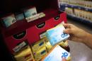 A woman takes tampon boxes out of a supermarket shelf in Buenos Aires