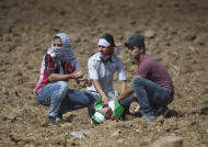 Palestinian demonstrators kneel around an injured comrade during clashes with Israeli troops near Ramallah, West Bank, Tuesday, Sept. 29, 2015. Palestinian demonstrators clashed with Israeli troops across the West Bank on Tuesday as tensions remained high following days of violence at Jerusalem’s most sensitive holy site, revered by Jews as the Temple Mount and by Muslims as the Noble Sanctuary. (AP Photo/Majdi Mohammed)