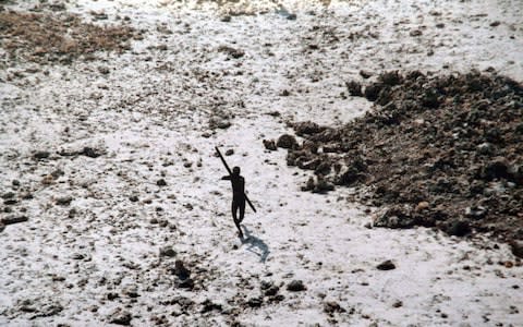 A Sentinelese man takes aim with a bow and arrow at an Indian Coast Guard helicopter in the wake of the 2004 tsunami - Credit:  HANDOUT/AFP