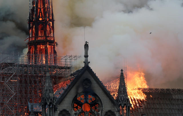 Smoke billows near scaffolding as fire engulfs the spire of Notre Dame Cathedral in Paris, France April 15, 2019. REUTERS/Benoit Tessier