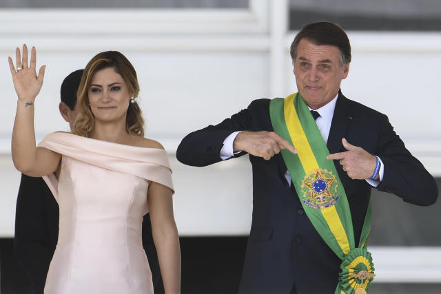 Brazil's new president Jair Bolsonaro (R) gstures next to his wife Michelle Bolsonaro, after receiveing the presidential sash from outgoing Brazilian president Michel Temer (out of frame), at Planalto Palace in Brasilia on January 1, 2019. - Bolsonaro takes office with promises to radically change the path taken by Latin America's biggest country by trashing decades of centre-left policies. (Photo by EVARISTO SA / AFP) (Photo credit should read EVARISTO SA/AFP/Getty Images)