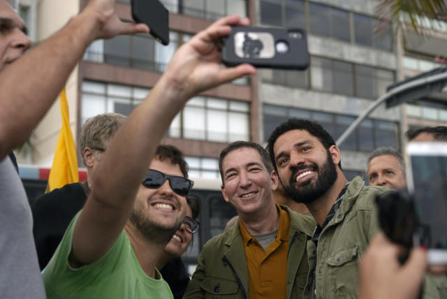 Deputado Federal David Miranda (à direita) ao lado do marido Gleen Greenwald (à esquerda) posando para foto com apoiadores - Foto: MAURO PIMENTEL/AFP/Getty Images