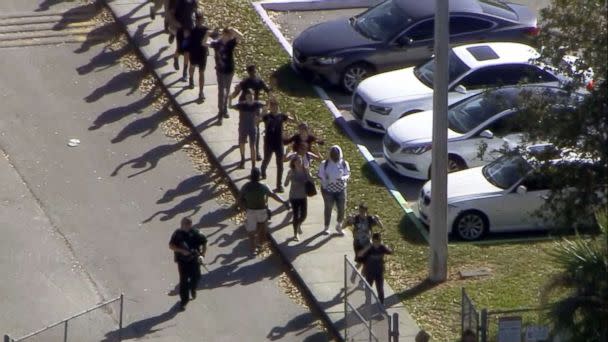 PHOTO: Students walk with an armed escort after reports of a shooting at Stoneman Douglas High School in Parkland, Fla., Feb. 14, 2018. (WPLG)