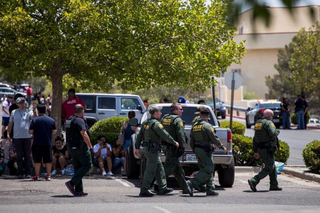 Customs and Border Patrol police walk past individuals that were evacuated from Cielo Vista Mall and a Wal-Mart where a shooting occurred in El Paso, Texas, Saturday, Aug. 3, 2019. - A shooting at a Walmart store in Texas left multiple people dead. At least one suspect was taken into custody after the shooting in the border city of El Paso, triggering fear and panic among weekend shoppers as well as widespread condemnation. It was the second fatal shooting in less than a week at a Walmart store in the US and comes after a mass shooting in California last weekend. (Photo by Joel Angel JUAREZ / AFP) (Photo credit should read JOEL ANGEL JUAREZ/AFP/Getty Images)