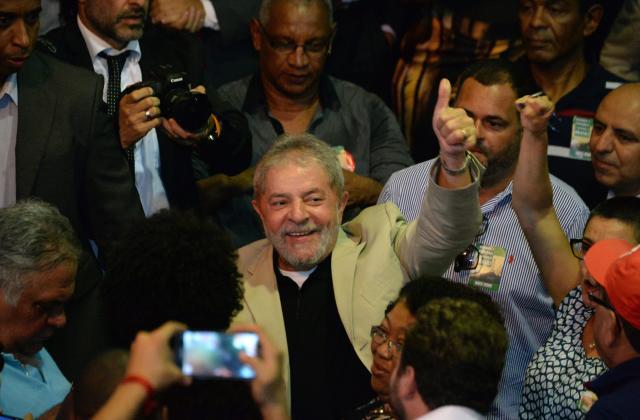 Brazilian former President Luiz Inácio Lula da Silva waves during a meeting with unionists and intellectuals in defense of state oil giant Petrobras, in Rio de Janeiro on February 24, 2015. Last week, Brazil's public prosecutor demanded that firms caught up in the huge kickbacks scandal at oil giant Petrobras pay some $1.5 billion in damages as well as yet-to-be-specified fines. AFP PHOTO/VANDERLEI ALMEIDA (Photo credit should read VANDERLEI ALMEIDA/AFP/Getty Images)