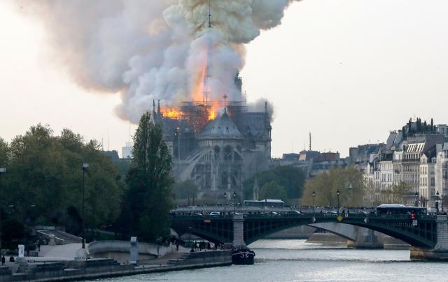 TOPSHOT - Smokes ascends as flames rise during a fire at the landmark Notre-Dame Cathedral in central Paris on April 15, 2019 afternoon, potentially involving renovation works being carried out at the site, the fire service said. (Photo by FRANCOIS GUILLOT / AFP) (Photo credit should read FRANCOIS GUILLOT/AFP/Getty Images)