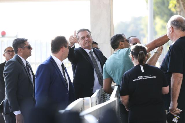 O presidente Jair Bolsonaro cumprimenta populares no Palácio da Alvorada. Foto: Antonio Cruz/ Agência Brasil