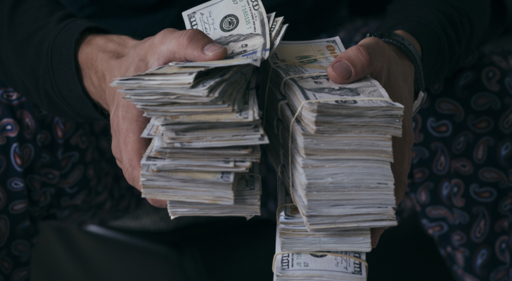 Man holding stacks of money. Millionaire.